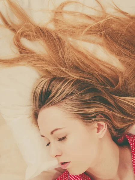 Young woman lying on bed wearing pajamas — Stock Photo, Image