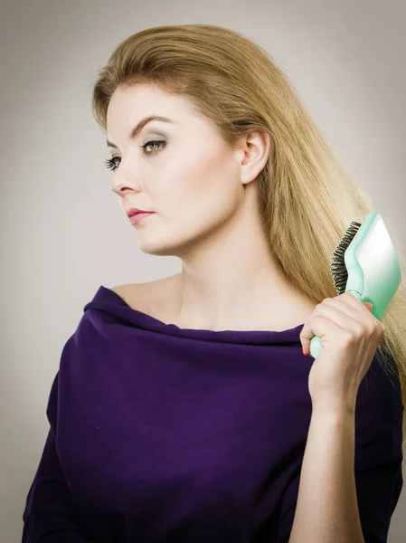 Donna spazzolando i capelli lunghi con la spazzola — Foto Stock