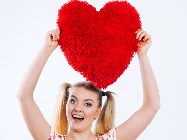 Happy woman holding heart shaped pillow — Stock Photo, Image