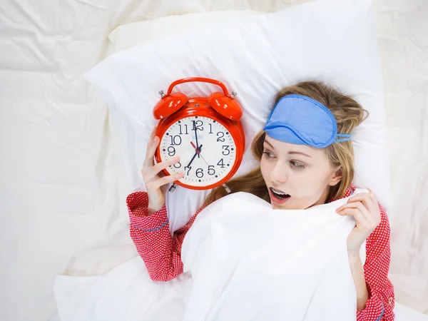 Zszokowana kobieta piżamie gospodarstwa zegar Zaspałem — Zdjęcie stockowe