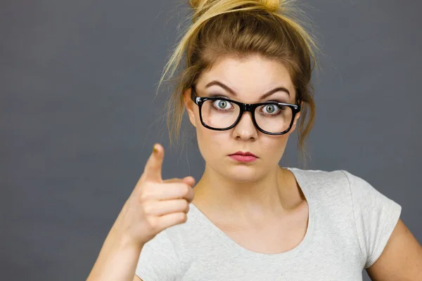 Woman wearing eyeglasses pointing at camera — Stock Photo, Image