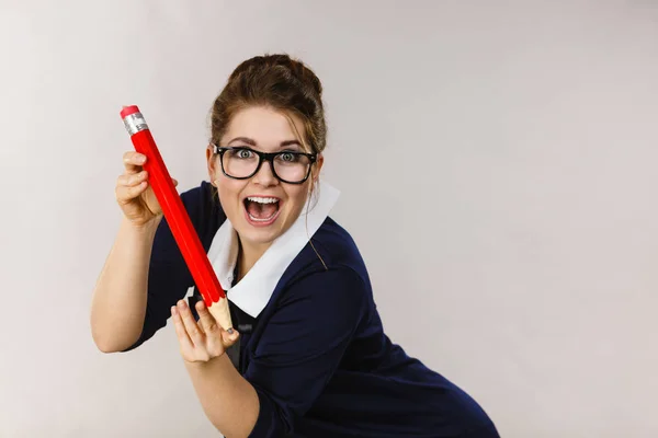 Lachende vrouw houdt grote potlood in de hand — Stockfoto