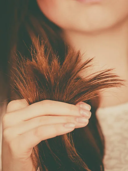 Kobieta, patrząc na jej końcach włosów suchych — Zdjęcie stockowe