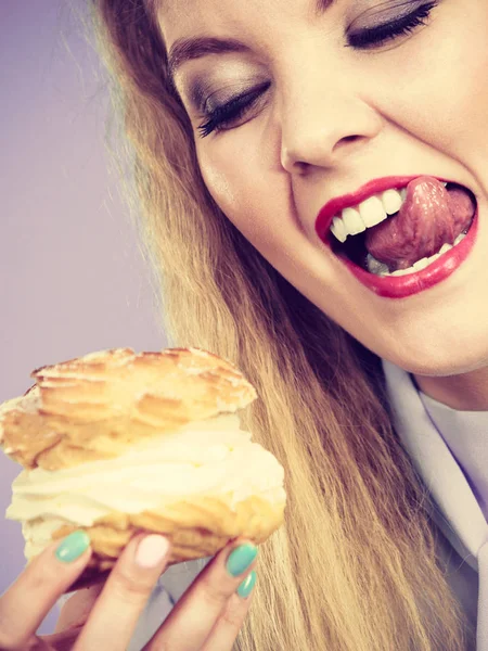 Funny woman holds cream puff cake — Stock Photo, Image