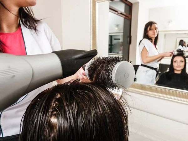 Kapper donkere vrouw haargroei met behulp van professionele föhn drogen — Stockfoto