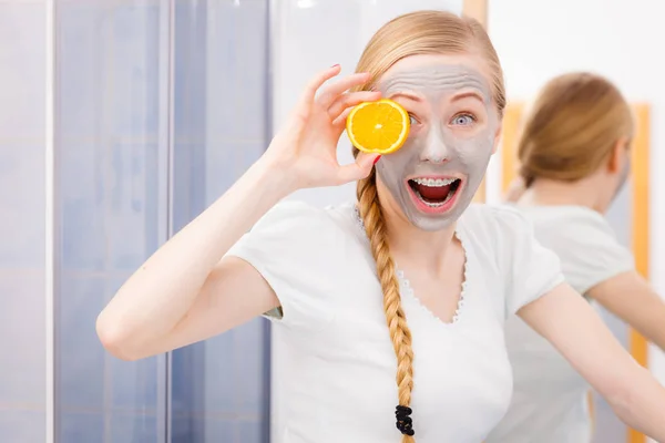 Glückliche junge Frau mit Gesichtsmaske und Kiwi — Stockfoto