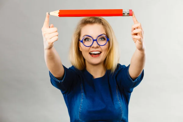 Leende kvinna håller stora penna i hand — Stockfoto