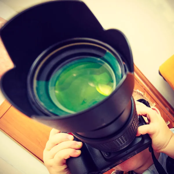 Kid playing with big professional digital camera — Stock Photo, Image