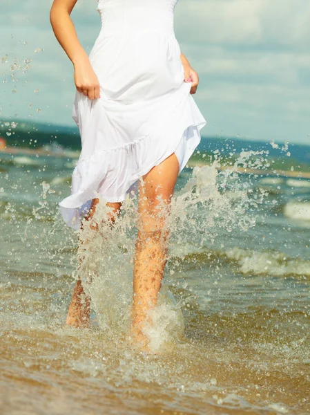 Blondine vrouw draagt jurk lopen in water — Stockfoto