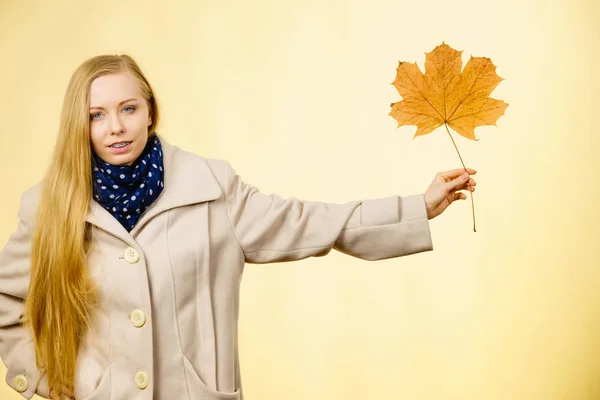 Woman holding orange autumn leaf — Stock Photo, Image