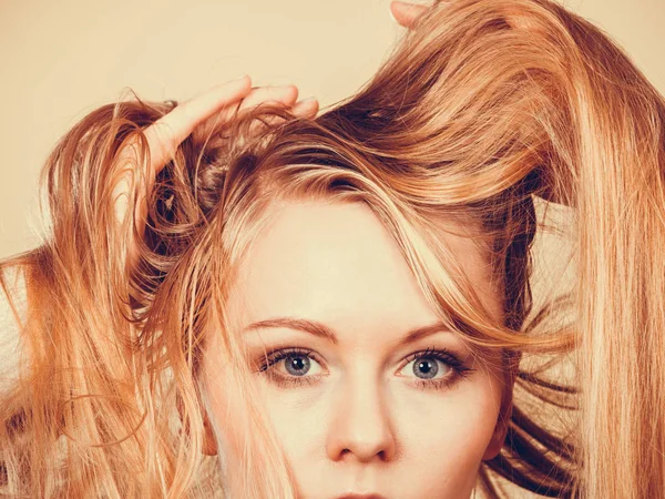 Ξανθιά γυναίκα που κρατά πολύ μπερδεμένα μαλλιά — Φωτογραφία Αρχείου
