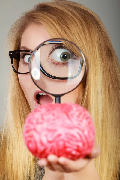 Жінка тримає збільшувальне скло, досліджуючи мозок — стокове фото