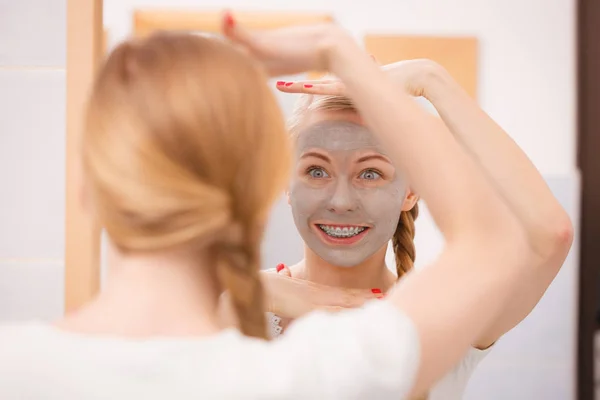 Vrouw met grijze klei modder masker op haar gezicht — Stockfoto