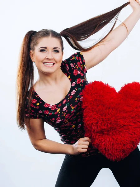 Mujer feliz sosteniendo almohada en forma de corazón — Foto de Stock