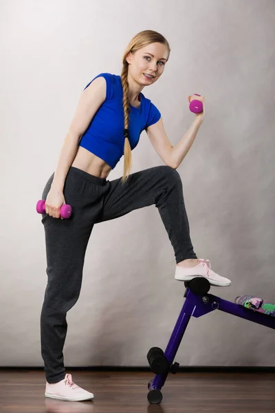 Teenage woman working out at home with dumbbell — Stock Photo, Image