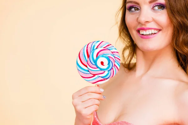 Donna tiene caramelle colorate lecca lecca in mano — Foto Stock