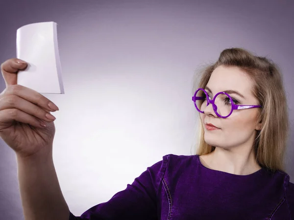 Thinking woman wearing eyeglasses holding note — Stock Photo, Image