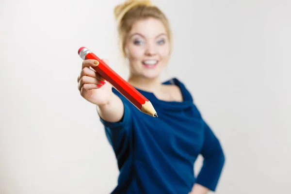 Щаслива жінка тримає даючи великий олівець — стокове фото