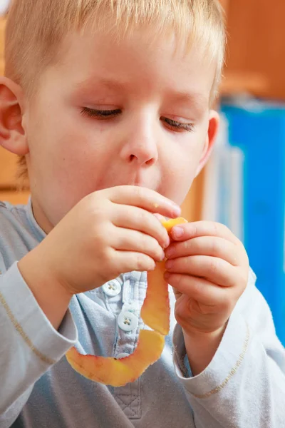 Мальчик ест яблоко на закуску — стоковое фото