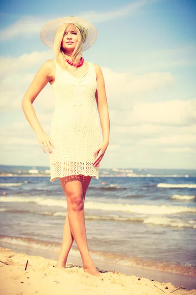 Блондинка в платье прогулка по пляжу — стоковое фото