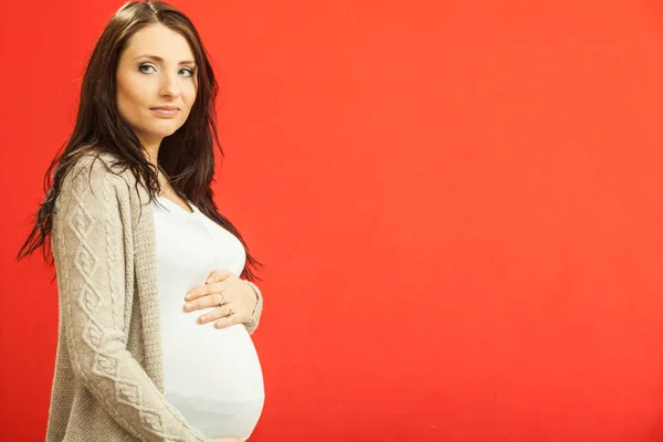 Pregnant young woman showing her belly — Stock Photo, Image