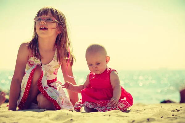 Kleinkind amüsiert sich mit Kind am Strand. — Stockfoto