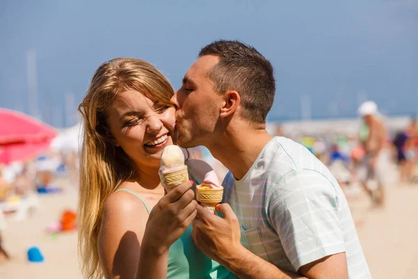 Mężczyzna i kobieta jedzący lody na plaży — Zdjęcie stockowe