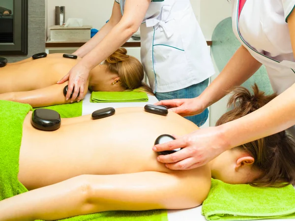 Massage mit heißen Steinen in Kosmetikerin — Stockfoto