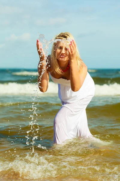 Blond kvinna bär klänning leker med vatten — Stockfoto