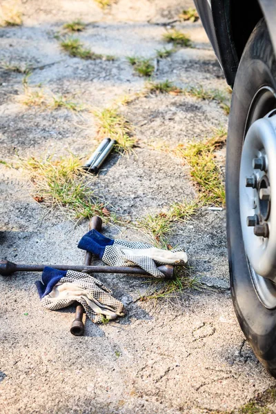 Hjulet hylsnyckel och jack liggande på marken — Stockfoto