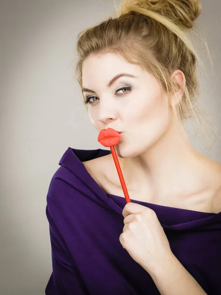 Rolig kvinna som håller stora röda läppar på pinne — Stockfoto