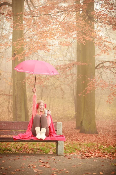 Chica en el parque de otoño disfrutando de bebida caliente — Foto de Stock