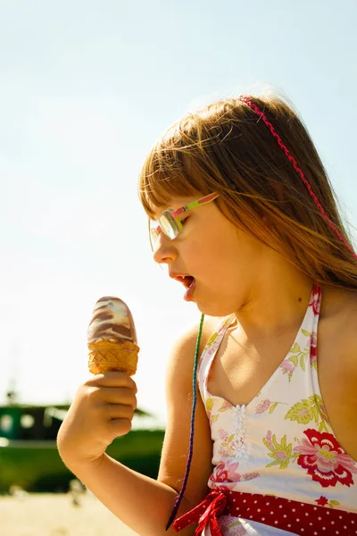 蹒跚学步的女孩，在海滩上吃冰淇淋 — 图库照片