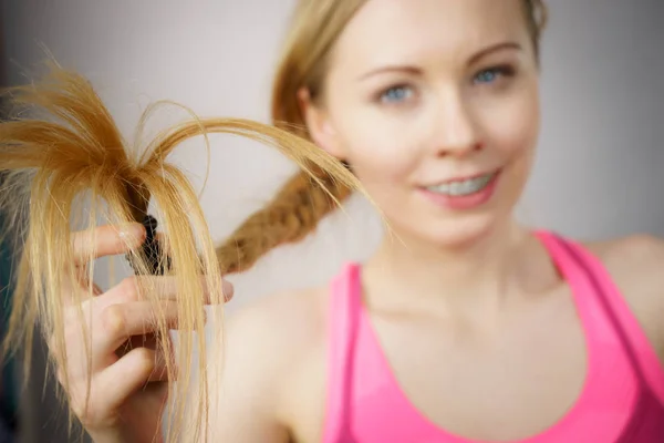 Счастливая женщина смотрит на концы волос — стоковое фото