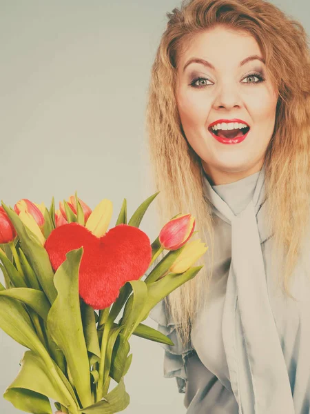 Kvinna håller tulpaner och rött hjärta — Stockfoto