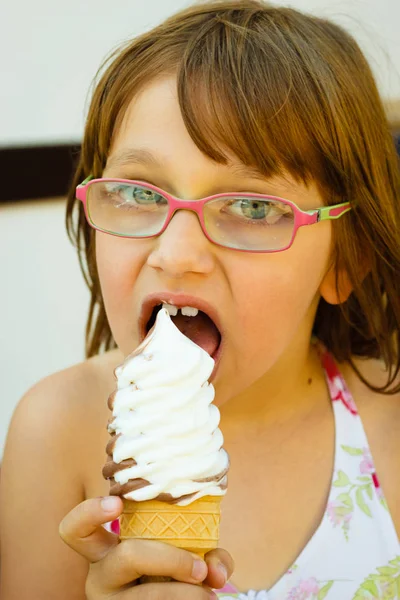 幼児女の子で眼鏡をかけて食べるアイスクリーム — ストック写真