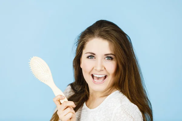 Gelukkige vrouw haar haren borstelen — Stockfoto