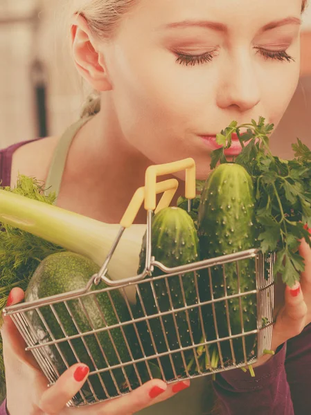 Mulher na cozinha com legumes segurando cesta de compras — Fotografia de Stock