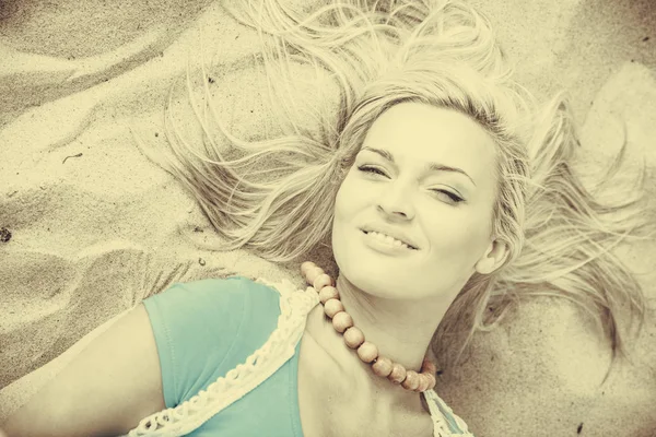 Blonde woman lying on sand. — Stock Photo, Image