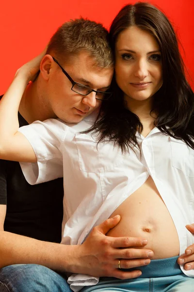 Έγκυος γυναίκα και άνδρα χαλαρώνοντας στον καναπέ — Φωτογραφία Αρχείου