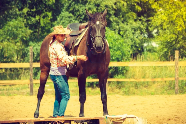 Cowgirl, příprava koně pro jízdu na venkově — Stock fotografie