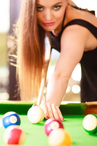 Jovem mulher bonita jogando sinuca sozinha segurando o taco na mesa de  bilhar