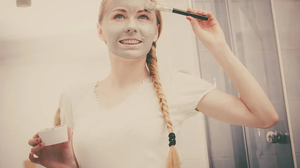 Vrouw met grijze klei modder masker op haar gezicht — Stockfoto