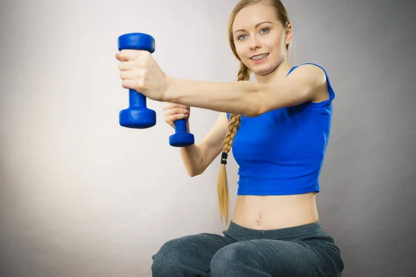 Teenage woman working out at home with dumbbell — Stock Photo, Image