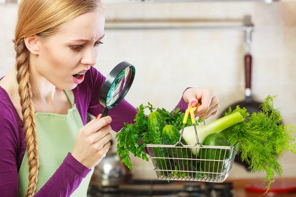 Femme regardant à travers loupe panier de légumes — Photo