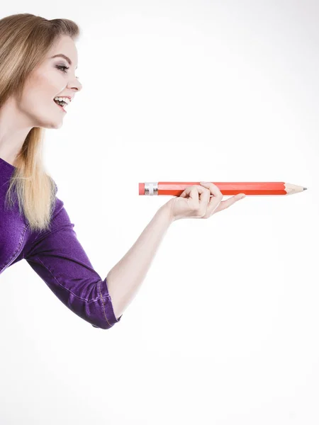 Lachende vrouw houdt grote potlood in de hand — Stockfoto