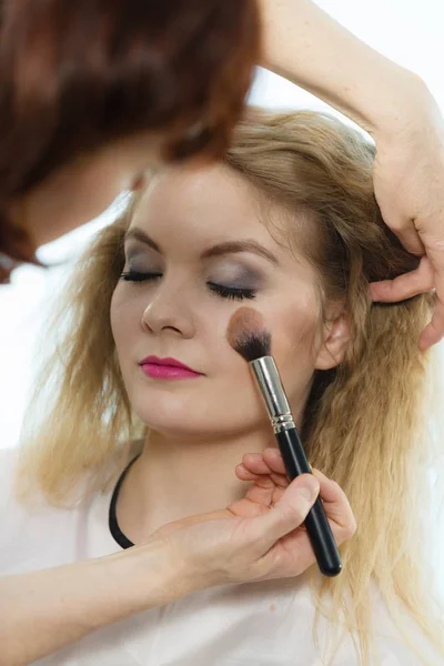 化妆师刷胭脂女性检查的应用 — 图库照片