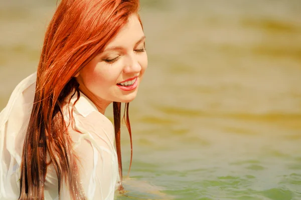 Redhead woman posing in water during summertime — Stock Photo, Image