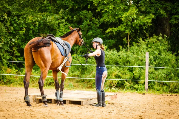 Jockey ung kvinna sig hästen redo för ride — Stockfoto