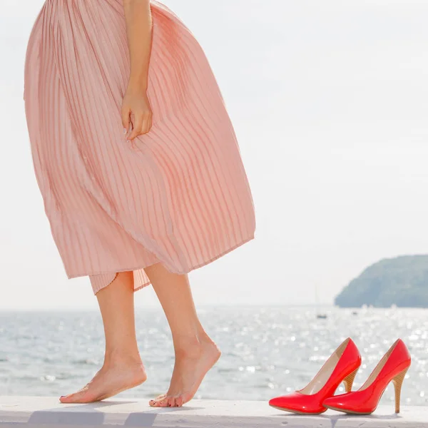 Vrouw lang licht roze jurk dragen op steiger — Stockfoto